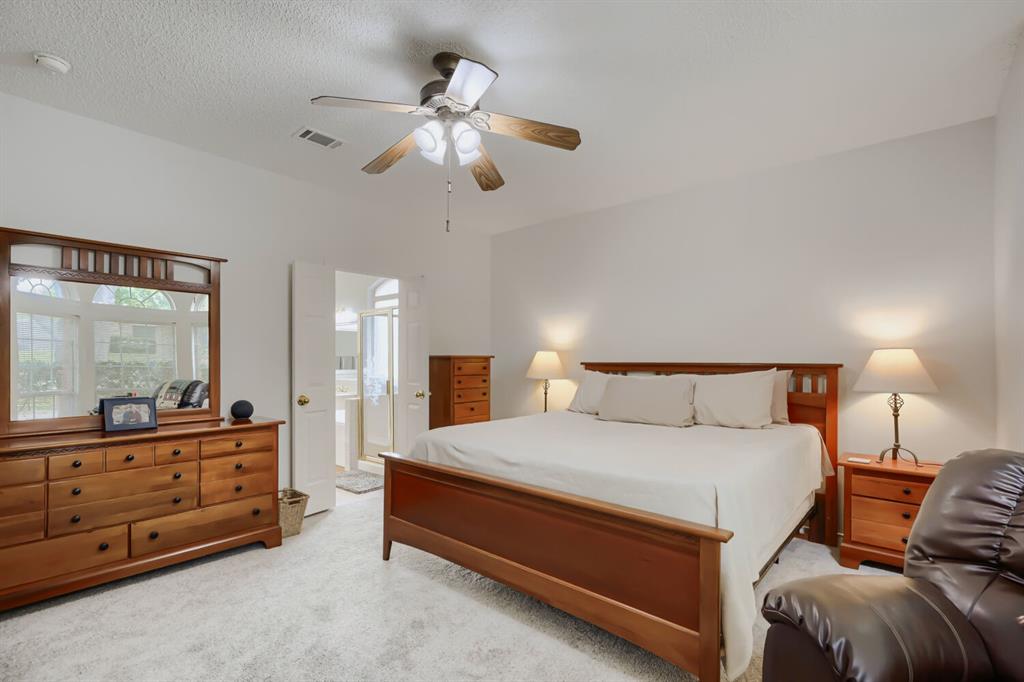 1413 West Peters Colony Road Carrollton, TX 75007 - Photo 18 of 29 a spacious bedroom with a bed and a dresser