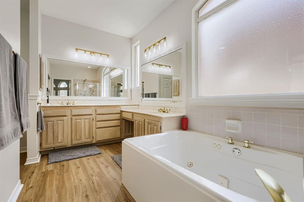 1413 West Peters Colony Road Carrollton, TX 75007 - Photo 19 of 29 a bathroom with a granite countertop sink mirror and bathtub
