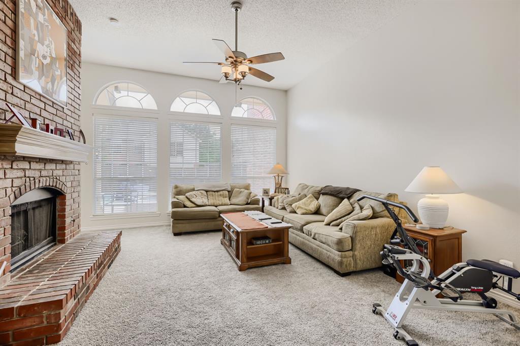 1413 West Peters Colony Road Carrollton, TX 75007 - Photo 9 of 29 a living room with furniture a fireplace and a chandelier