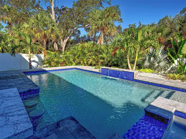 a large kitchen with stainless steel appliances kitchen island a large stove a refrigerator white cabinets and wooden floor