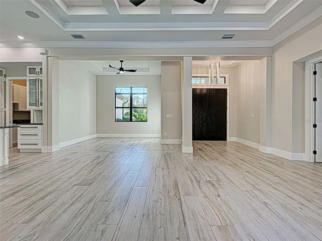 a view of a big room with wooden floor and a kitchen