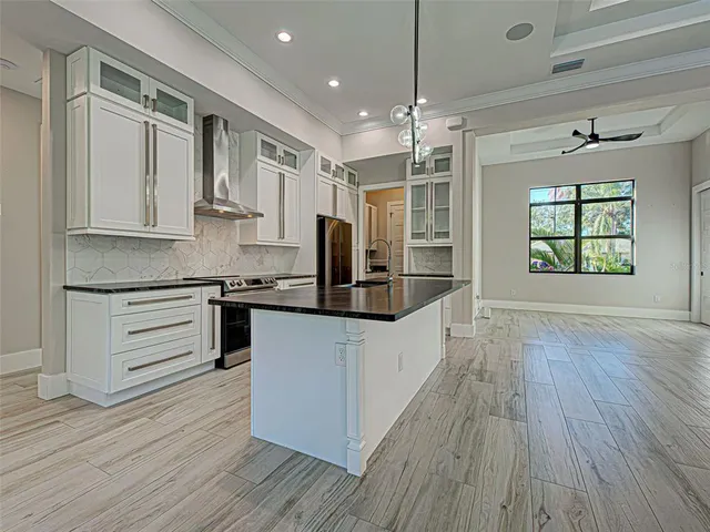 a kitchen with granite countertop white cabinets and stainless steel appliances