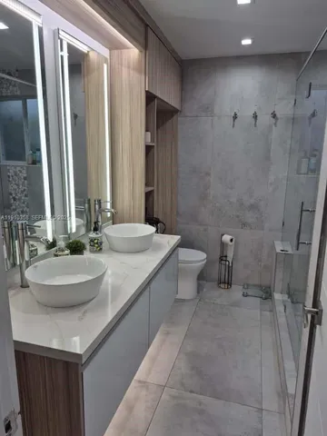 a bathroom with a sink a toilet and a mirror