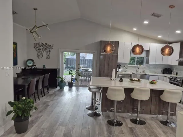 a dining room with wooden floor a glass table and chairs