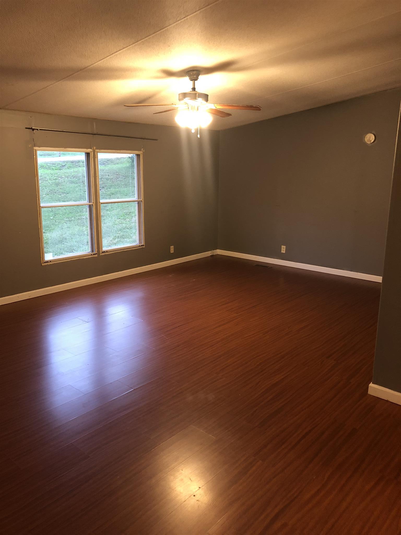 173 Roberts Road Portland, TN 37148 - Photo 5 of 7 an empty room with wooden floor and windows
