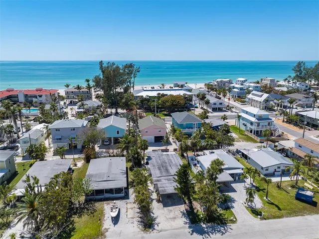 an aerial view of a city with lots of residential buildings and ocean view in back