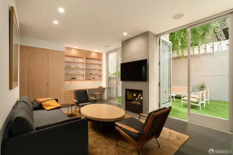 a living room with furniture a flat screen tv and a fireplace