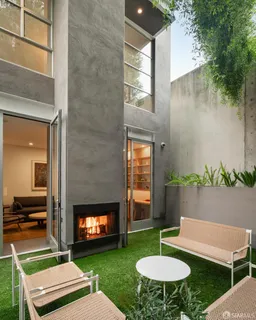 a backyard of a house with fireplace table and sofas