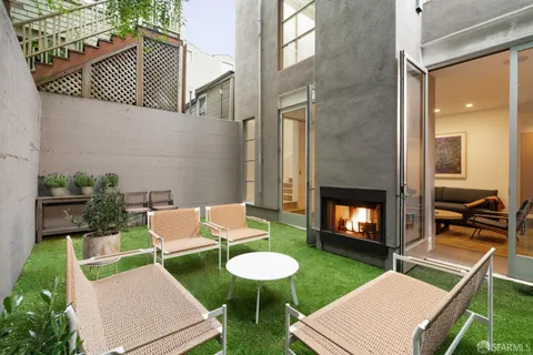 a backyard of a house with fireplace table and chairs