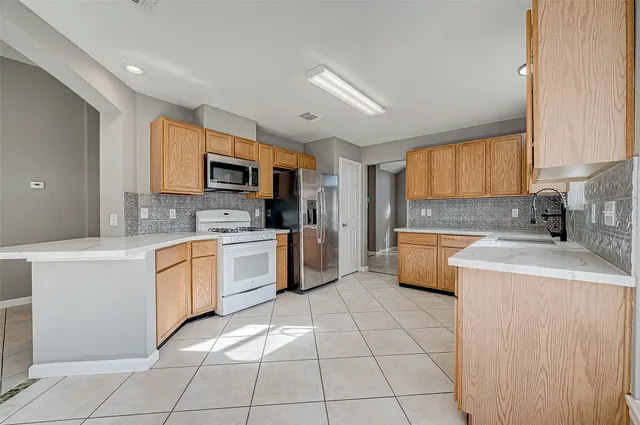 a kitchen with a sink a stove top oven and cabinets