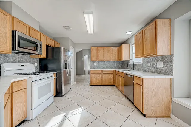 a kitchen with stainless steel appliances granite countertop a stove a sink and a refrigerator