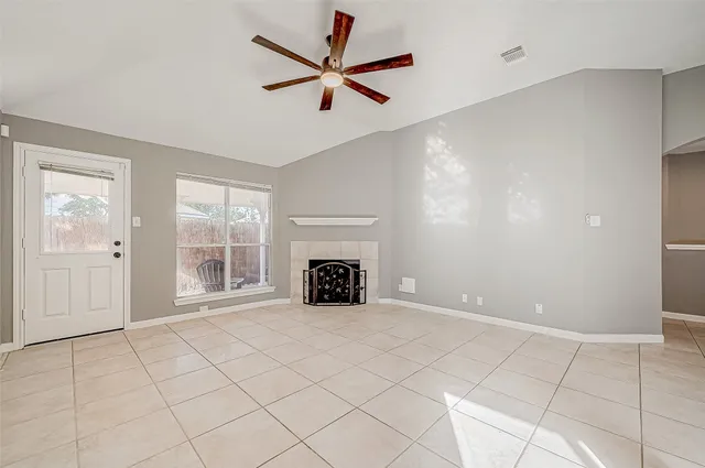 a view of an empty room with a fireplace and a window