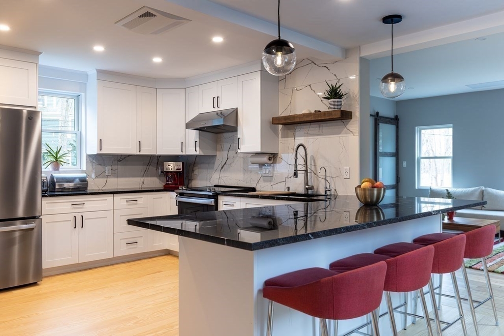 a kitchen with stainless steel appliances granite countertop a sink a stove a refrigerator a microwave oven with cabinets