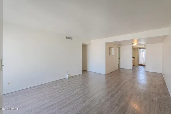 a view of a big room with wooden floor and windows