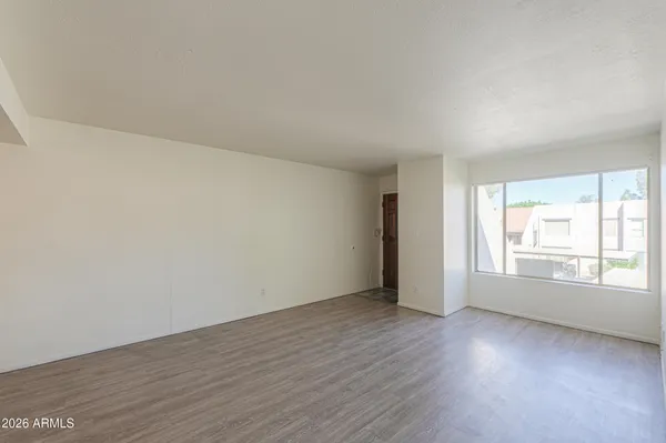 an empty room with wooden floor and window