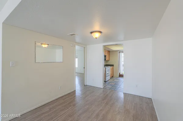 a view of a hallway with wooden floor and a bathroom