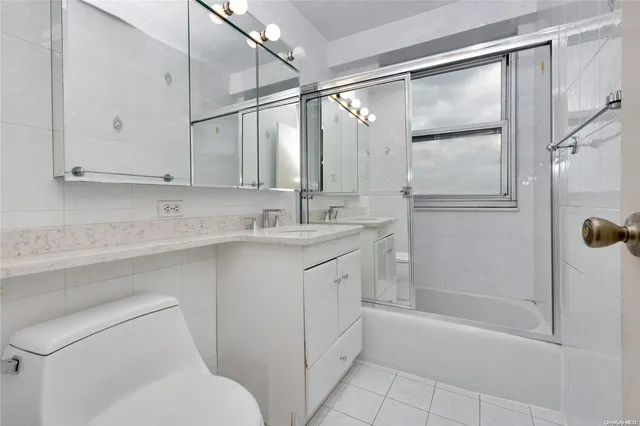 a bathroom with a granite countertop sink mirror vanity and toilet