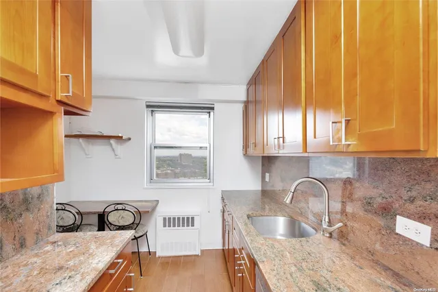 a kitchen with granite countertop a sink a stove and cabinets