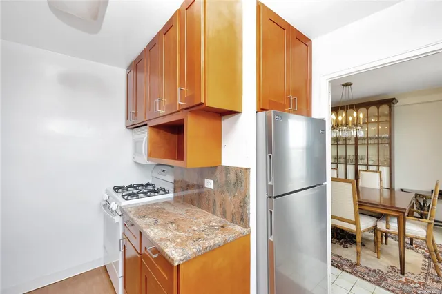a kitchen with stainless steel appliances granite countertop a refrigerator and a stove