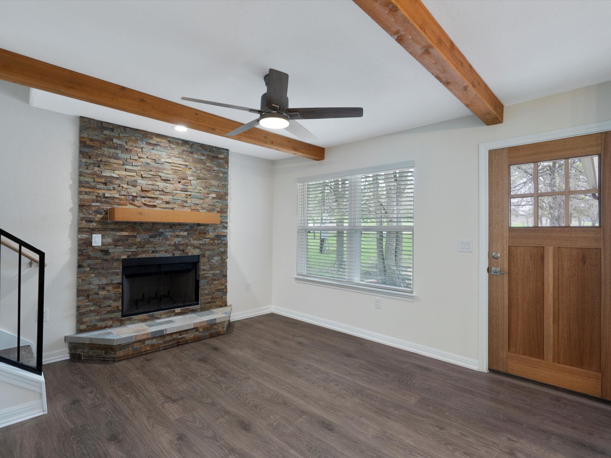 21007 Coleman Branch Creek Road Manor, TX 78653 - Photo 7 of 30 Bright living room featuring wood beam ceilings and a stone fireplace.