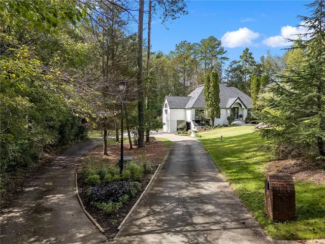 a front view of a house with a yard and trees
