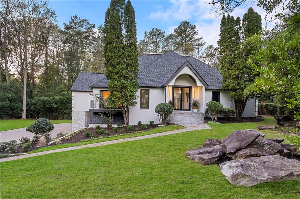 11260 Houze Road Roswell, GA 30076 - Photo 2 of 60 a front view of a house with a yard and garage
