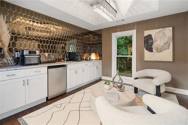 a kitchen with stainless steel appliances kitchen island granite countertop a table chairs in it and a window