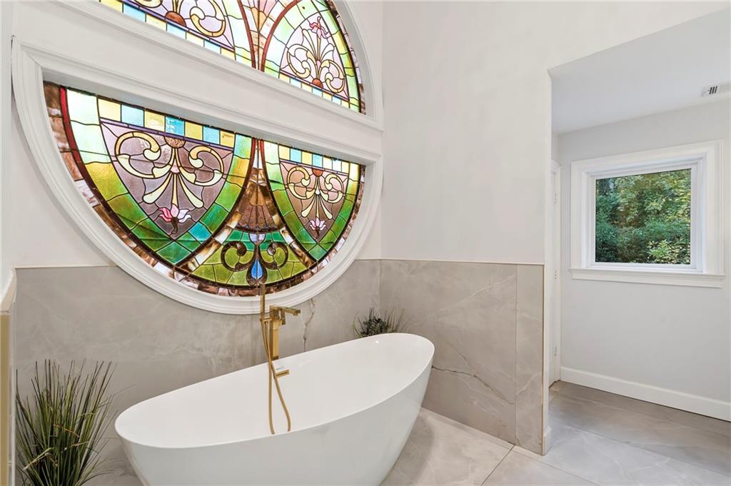 11260 Houze Road Roswell, GA 30076 - Photo 42 of 60 a bathroom with a bathtub and mirror