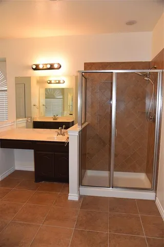 a bathroom with a granite countertop sink a mirror and a shower