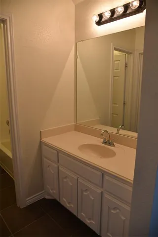 a bathroom with a granite countertop sink and mirror