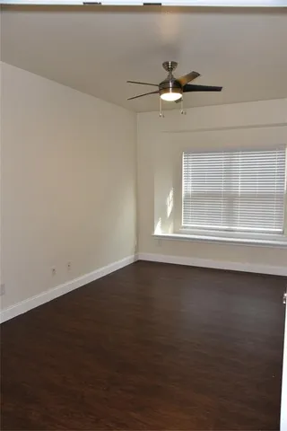 en empty room with wooden floor and windows