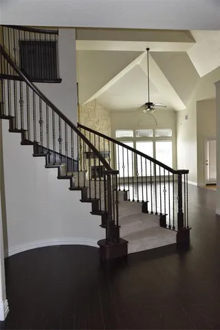 a view of staircase with railing and a chandelier