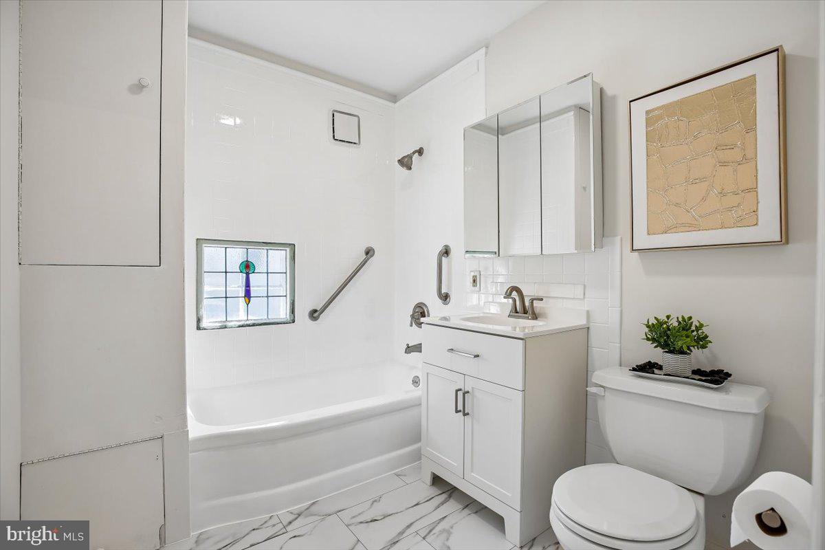 4714 Hunt Avenue Chevy Chase, MD 20815 - Photo 31 of 54 a bathroom with a granite countertop toilet a sink and bathtub