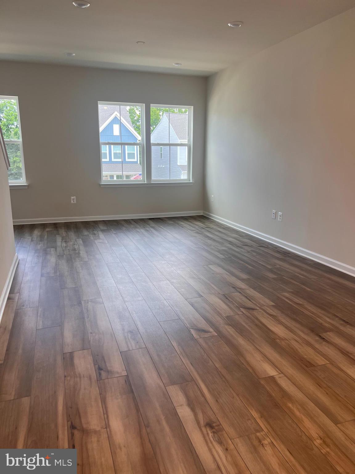 311 Sandy Btm Circle Ranson, WV 25438 - Photo 23 of 33 an empty room with wooden floor and windows