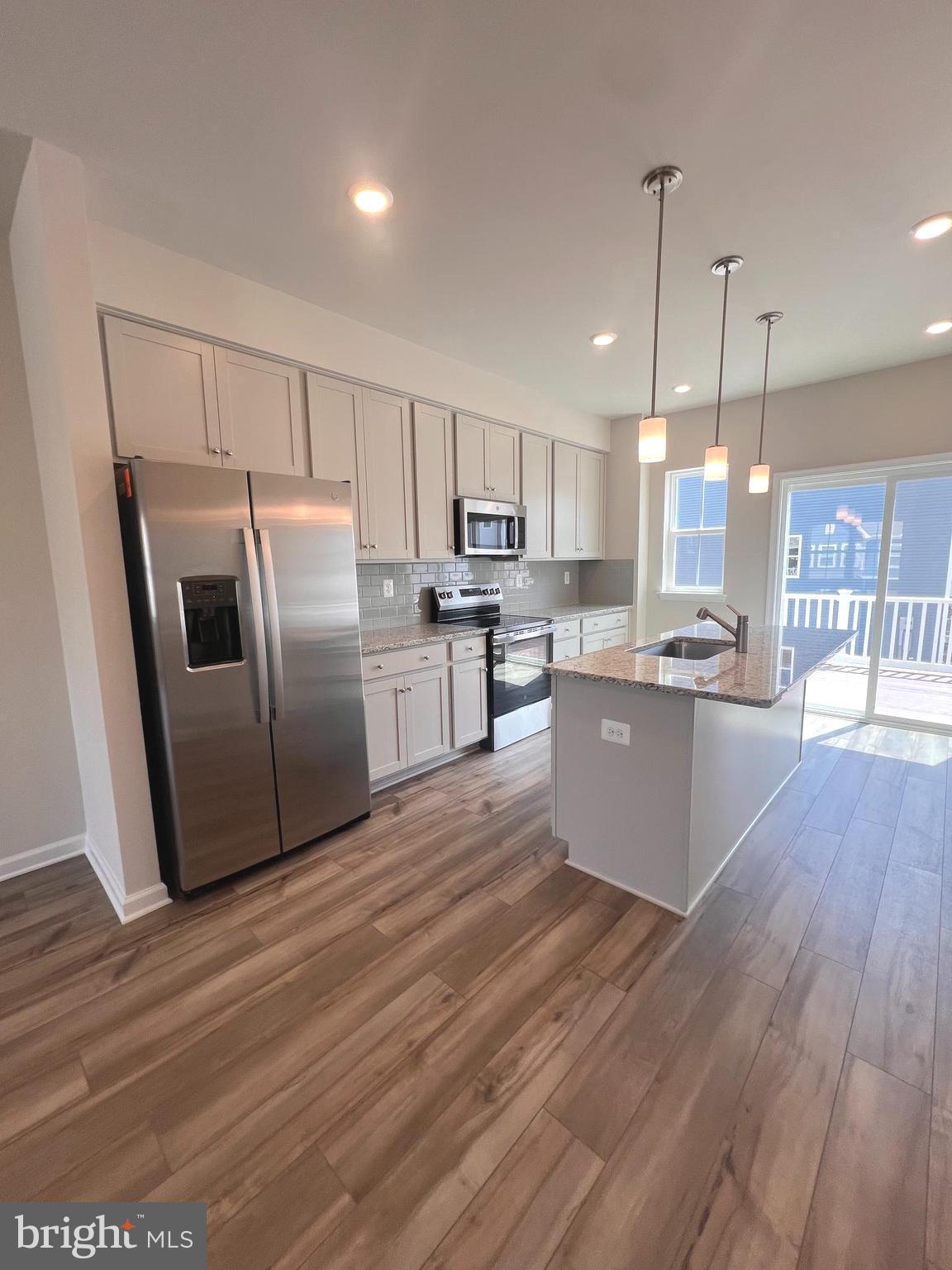 311 Sandy Btm Circle Ranson, WV 25438 - Photo 24 of 33 a kitchen with stainless steel appliances granite countertop a refrigerator a sink dishwasher a stove and white countertops with wooden floor