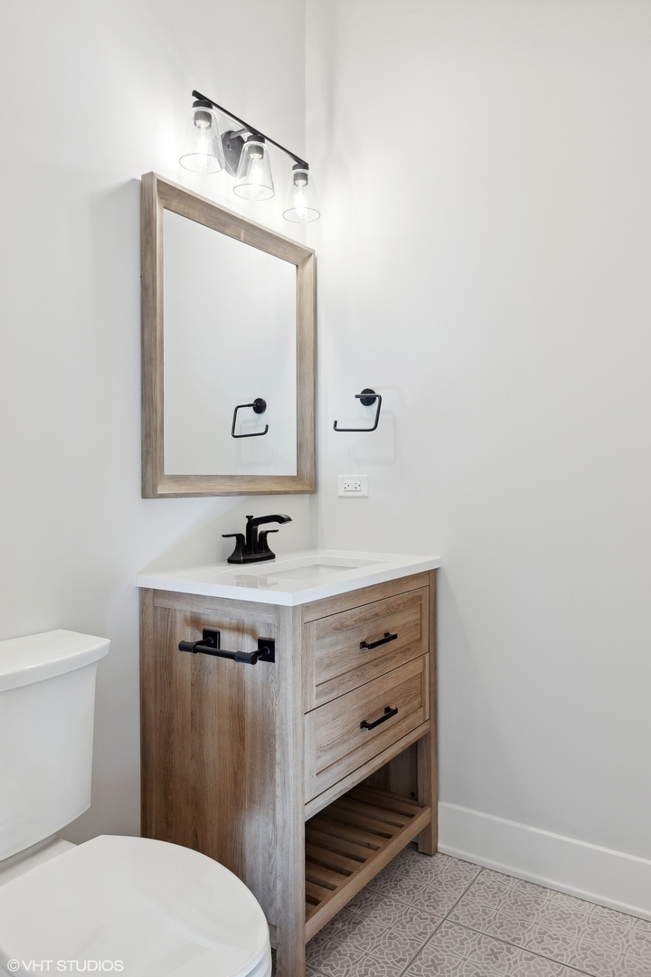 3414 North Tripp Avenue Chicago, IL 60641 - Photo 17 of 38 a bathroom with a toilet a sink and mirror