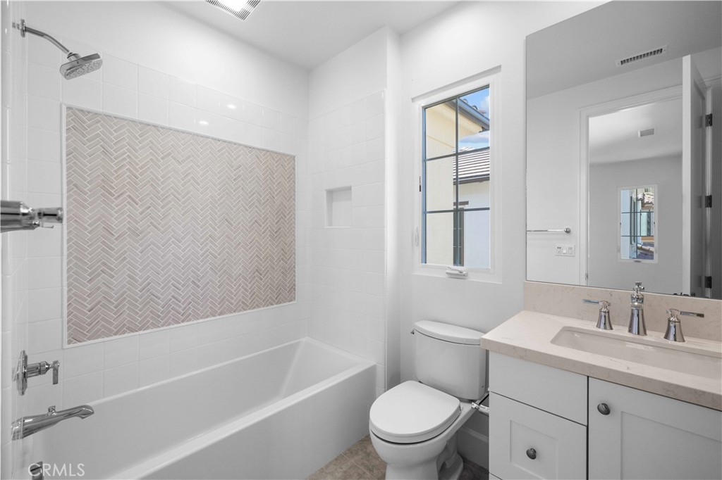 220 Fiore Irvine, CA 92602 - Photo 16 of 26 a bathroom with a toilet a sink a mirror a bathtub and vanity