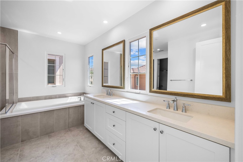 220 Fiore Irvine, CA 92602 - Photo 21 of 26 a bathroom with a sink double vanity granite tub shower and a mirror