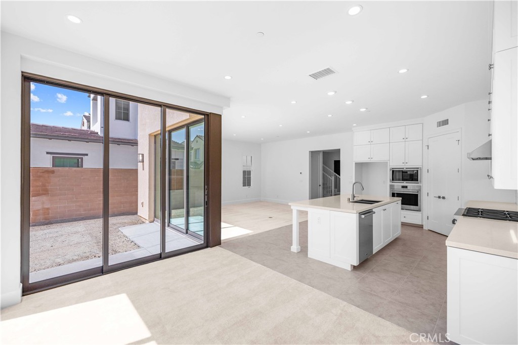 220 Fiore Irvine, CA 92602 - Photo 6 of 26 a large white room with kitchen view and a fireplace