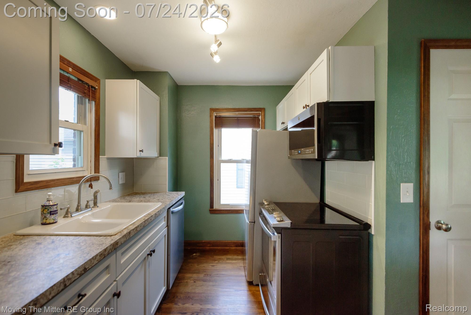 2037 Vivian Road Monroe, MI 48162 - Photo 8 of 39 Kitchen featuring wood-finish flooring, white cabinetry, and light-toned countertops
