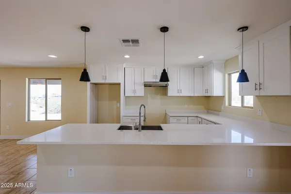 a kitchen with stainless steel appliances granite countertop a sink a stove and a refrigerator