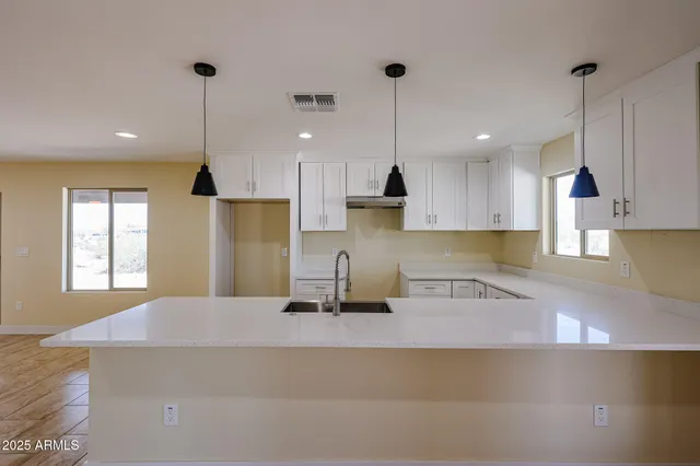 a kitchen with stainless steel appliances granite countertop a sink a stove and a refrigerator