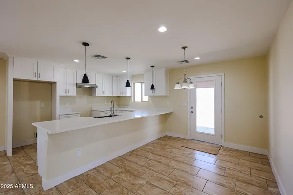 a large kitchen with kitchen island a sink stainless steel appliances and cabinets