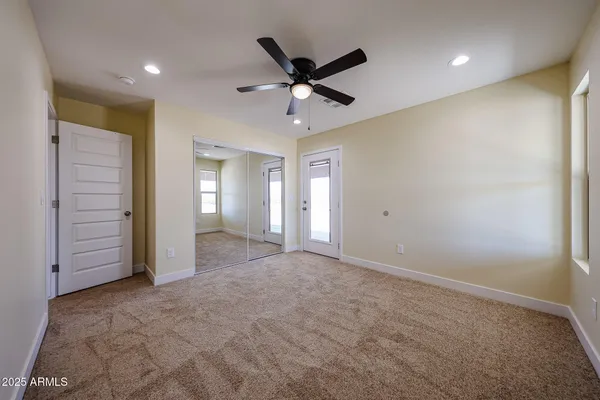a view of an empty room with a ceiling fan