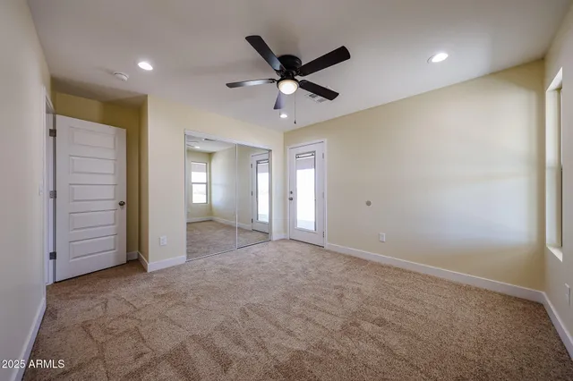 a view of an empty room with a ceiling fan