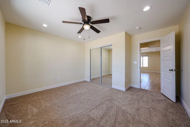 a view of a livingroom with a ceiling fan and entryway