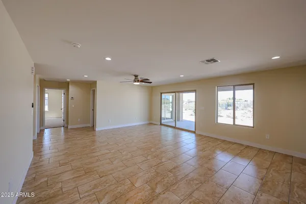 a view of an empty room with glass door and windows
