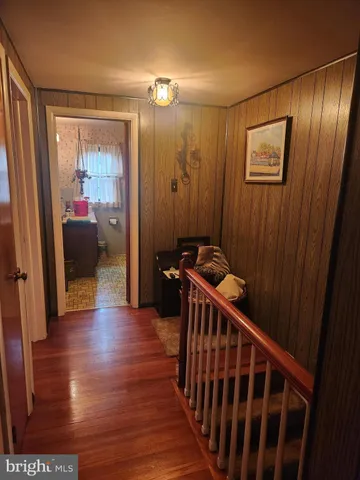 a view of a hallway with wooden floor and stairs