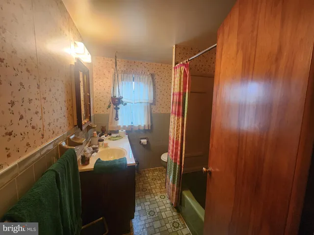 a bathroom with a sink and mirror with bathtub