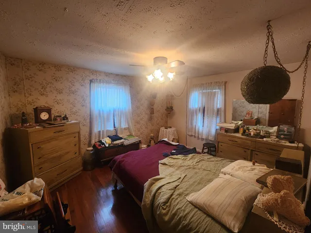 a bedroom with a bed a chandelier and dresser